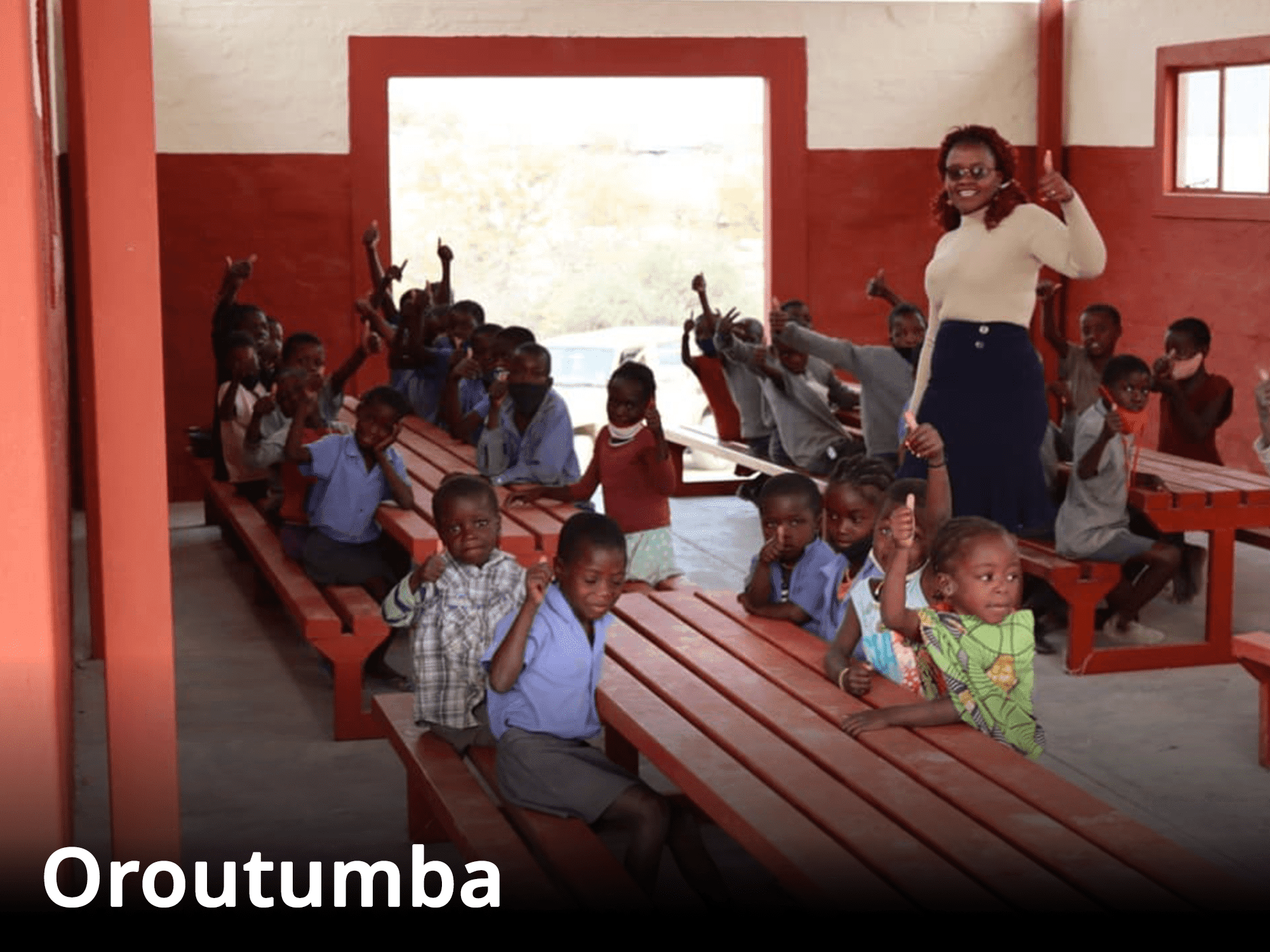 Bild von einem Aufenthaltsraum in der Schule in Oroutumba mit einer Lehrerin und vielen Schulkindern.